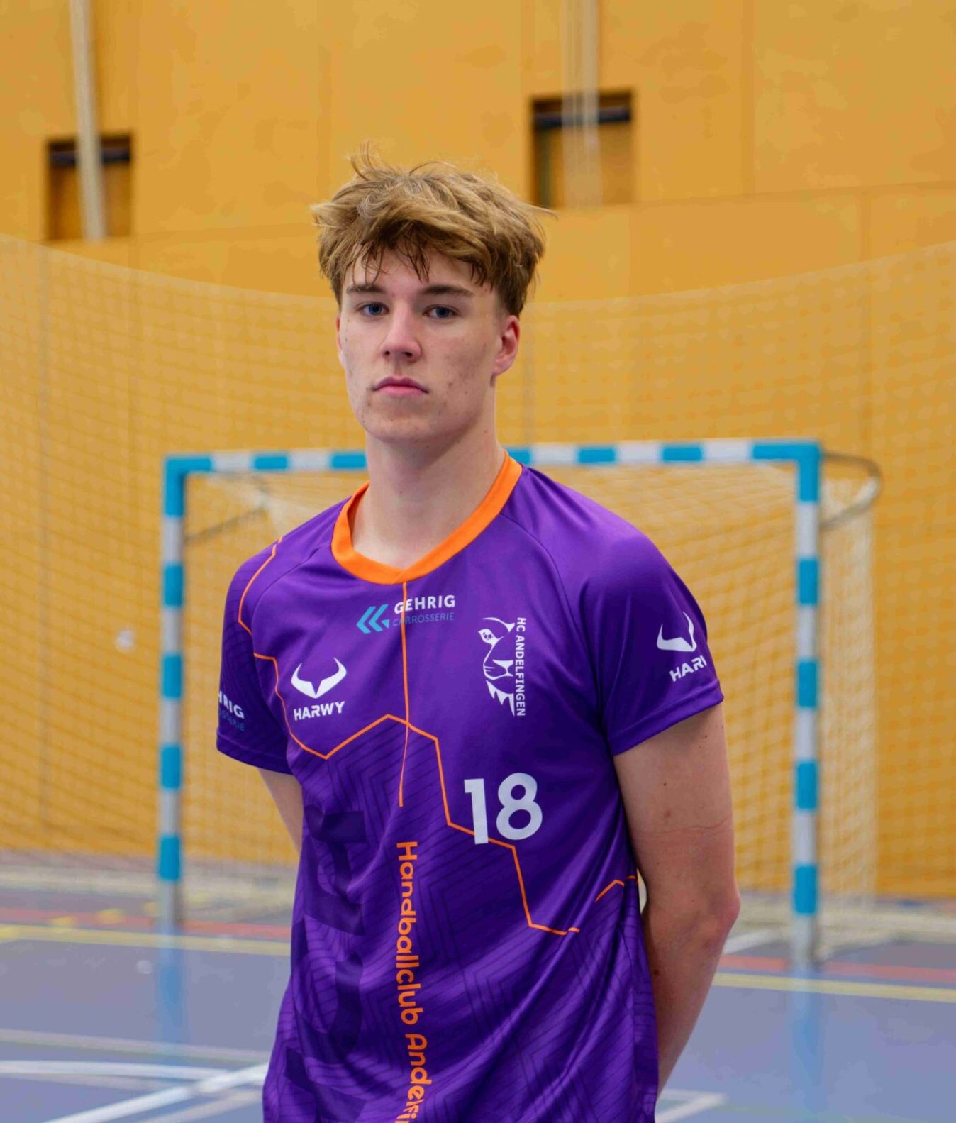 Handball Torwart posiert mit individuell designtem lila Vereinstrikot von HARWY