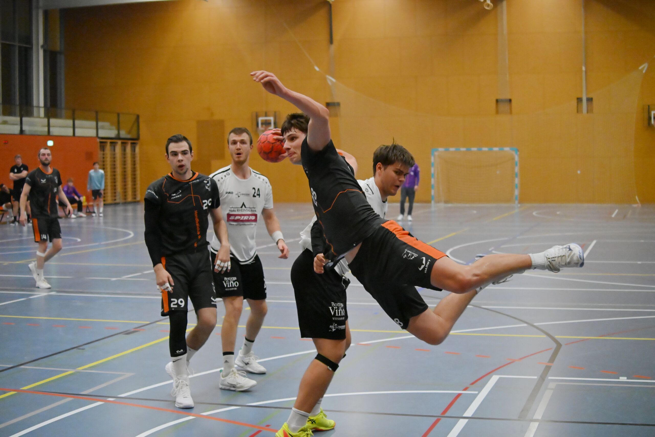 Dynamische Handball Spielszene des HC Andelfingen in dunkler HARWY Sportbekleidung